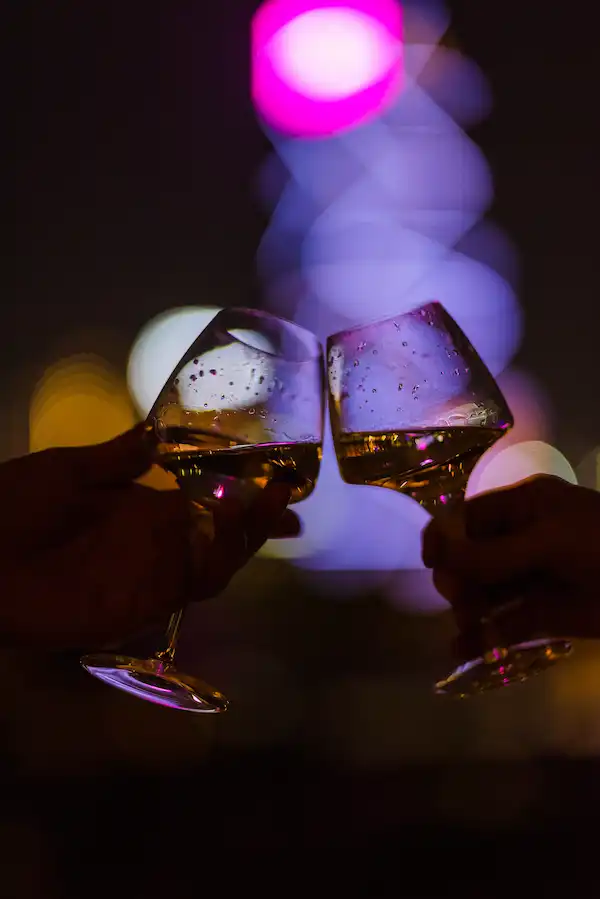 two-people-cheering-with-glasses-at-night-2022-11-04-04-50-27-utc